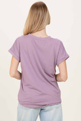 woman wearing a lavender short sleeve top, viewed from the back, styled with a relaxed fit