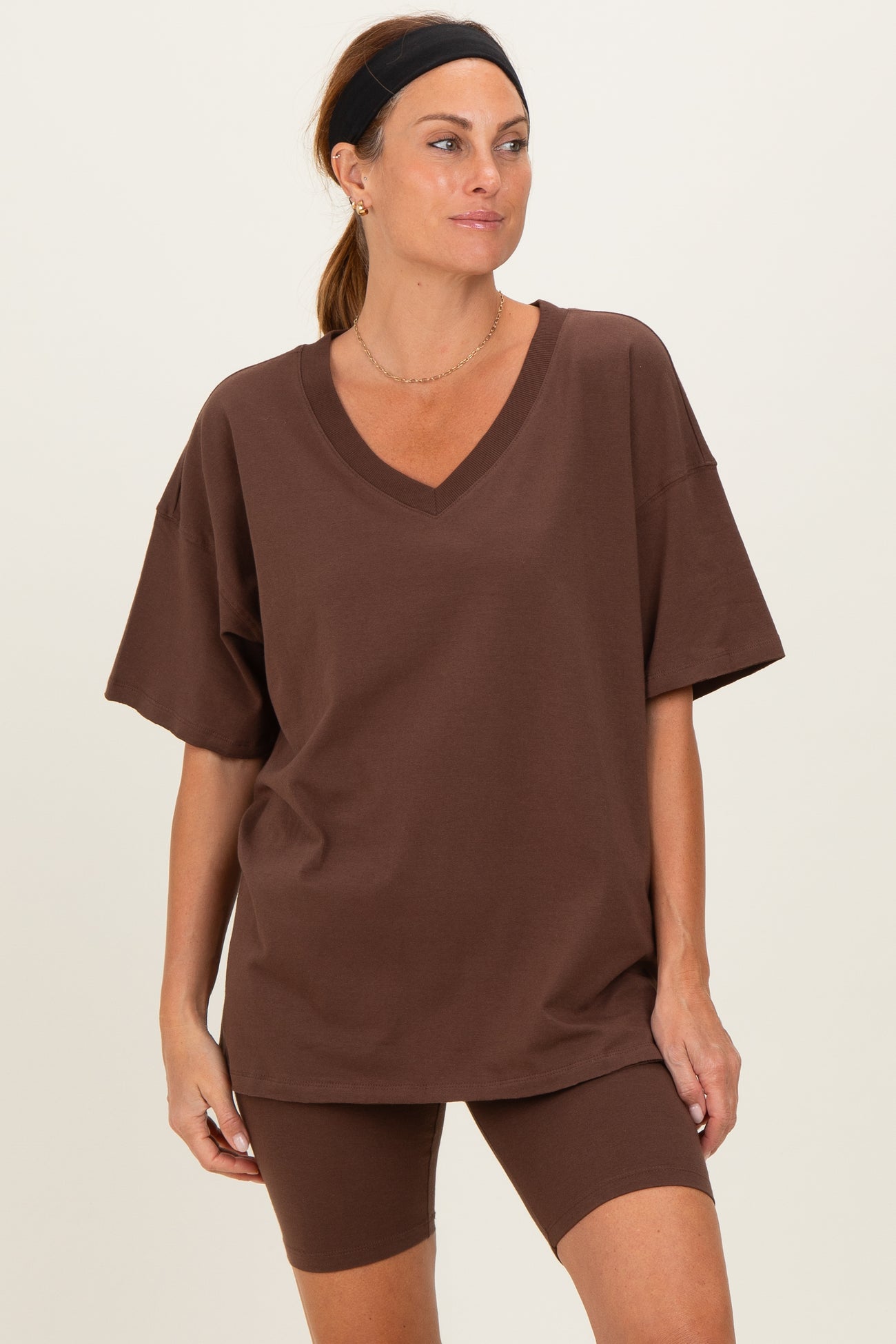 woman wearing a brown oversized v-neck t-shirt and matching bike shorts
