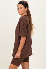 woman wearing a brown oversized t-shirt and matching bike shorts, styled with a headband