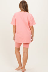 woman wearing a pink oversized maternity t-shirt and matching cycling shorts, showing a comfortable loungewear outfit
