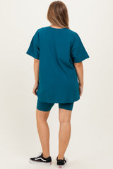 woman wearing a teal maternity t-shirt and matching bike shorts, showing a relaxed style from the back