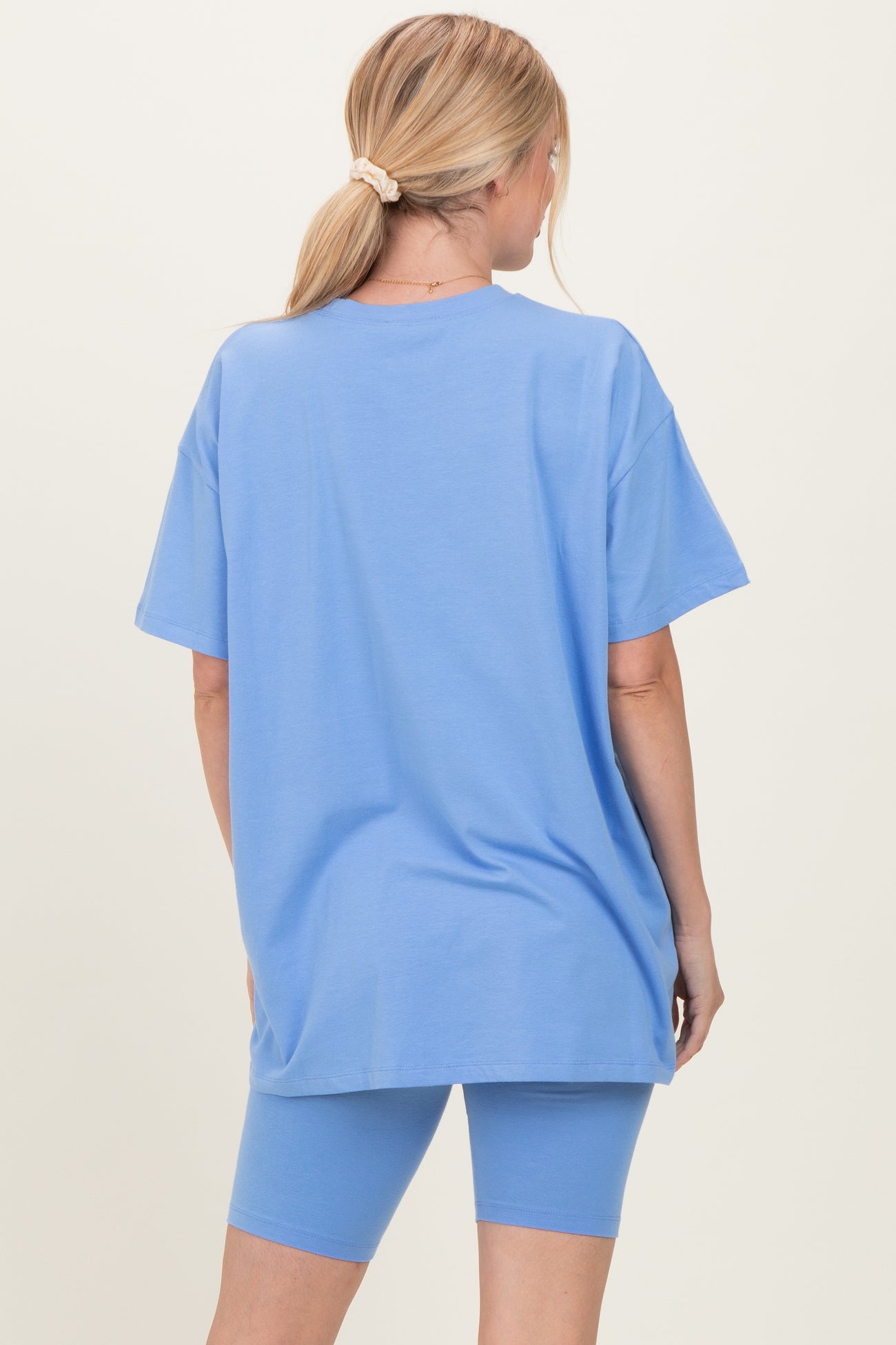 woman wearing a light blue oversized t-shirt and matching bike shorts, seen from the back