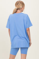woman wearing a light blue oversized t-shirt and matching bike shorts, seen from the back