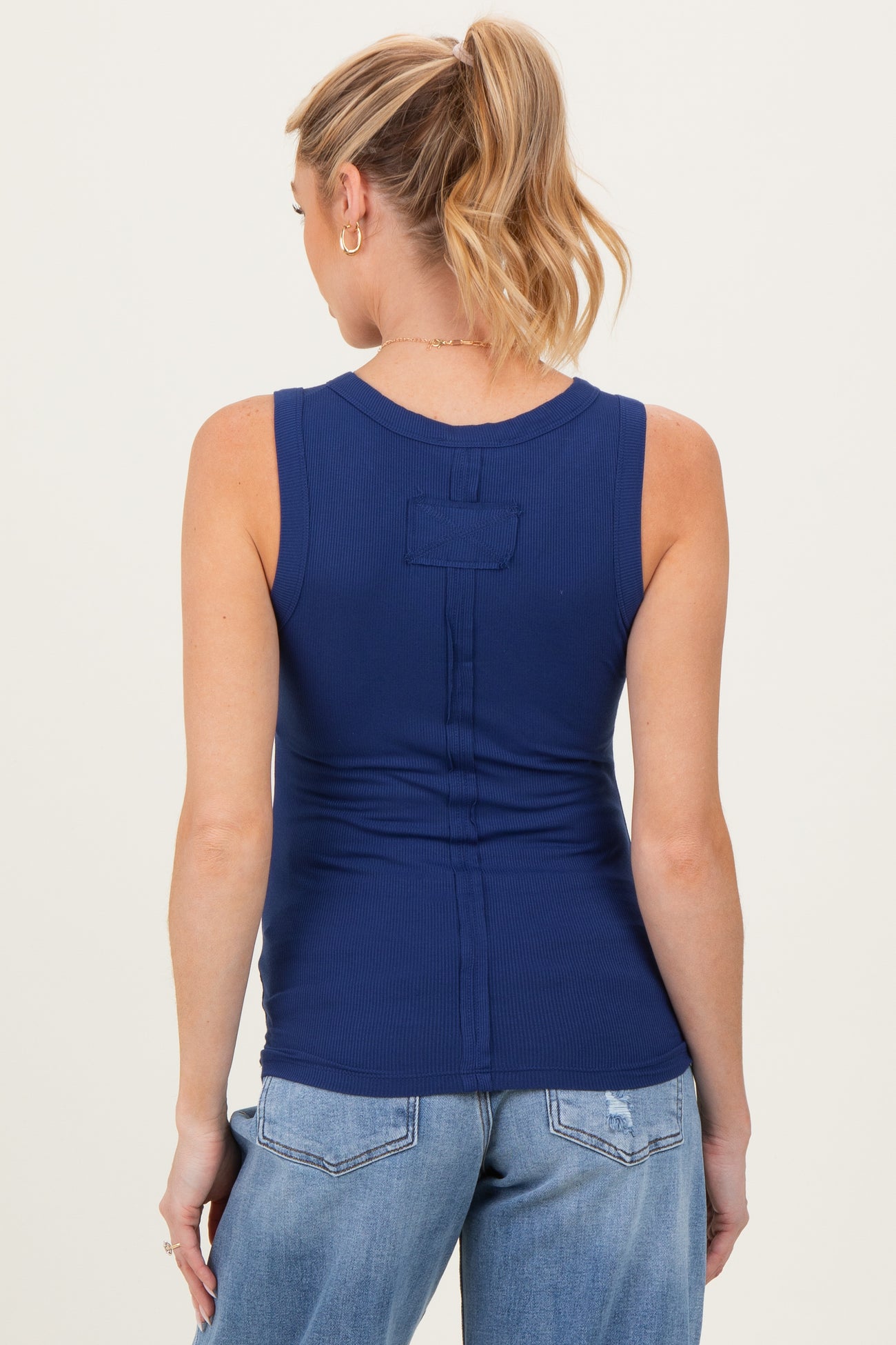 woman wearing a navy blue maternity tank top, showing a fitted style and ribbed texture from the back