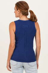 woman wearing a dark blue sleeveless ribbed top with a back button detail and light blue jeans