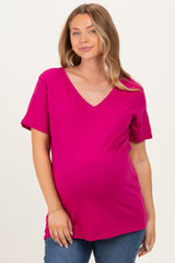 woman wearing a hot pink v-neck short sleeve maternity top and showing her baby bump