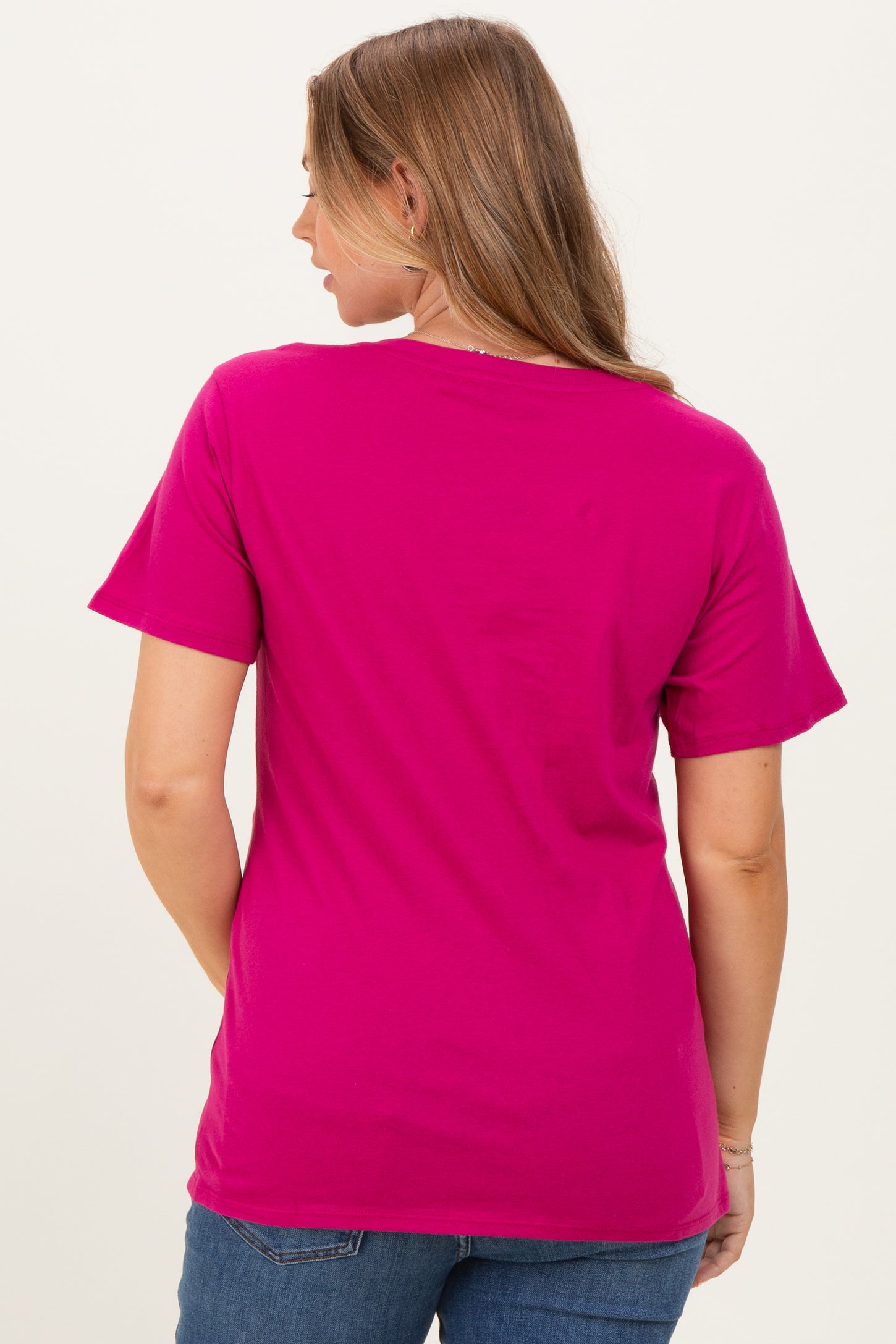 woman wearing a bright pink maternity t-shirt, shown from the back with short sleeves and a relaxed fit