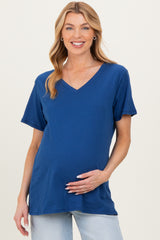 woman wearing a navy blue short sleeve v-neck maternity top and holding her baby bump