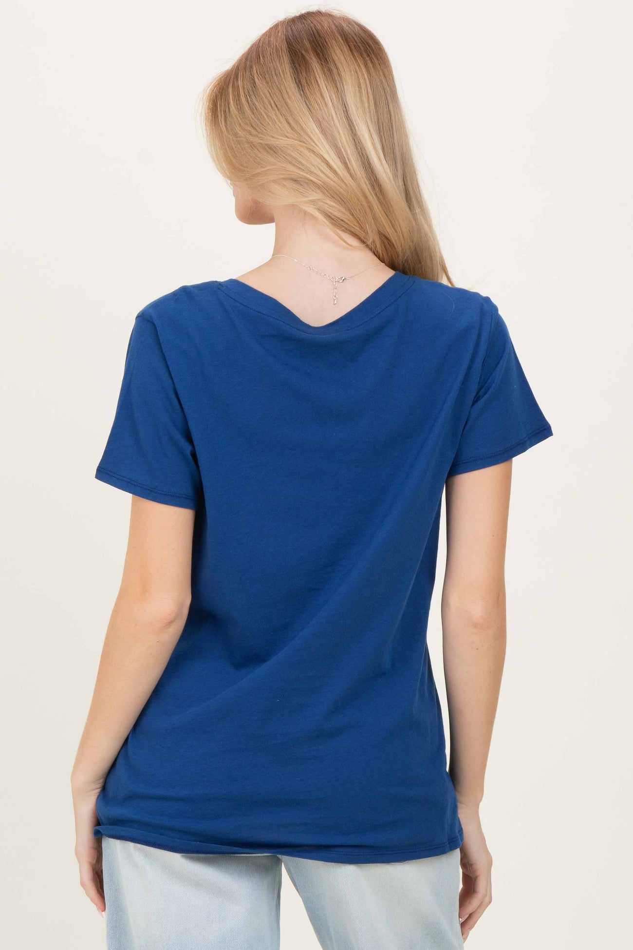 woman wearing a navy blue short sleeve t-shirt viewed from the back with a v-neckline