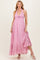 woman wearing a pink halter neck maternity dress with a tiered ruffle skirt and a baby bump visible