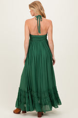 woman wearing a green maternity maxi dress with a smocked bodice and ruffled hem, showing her back