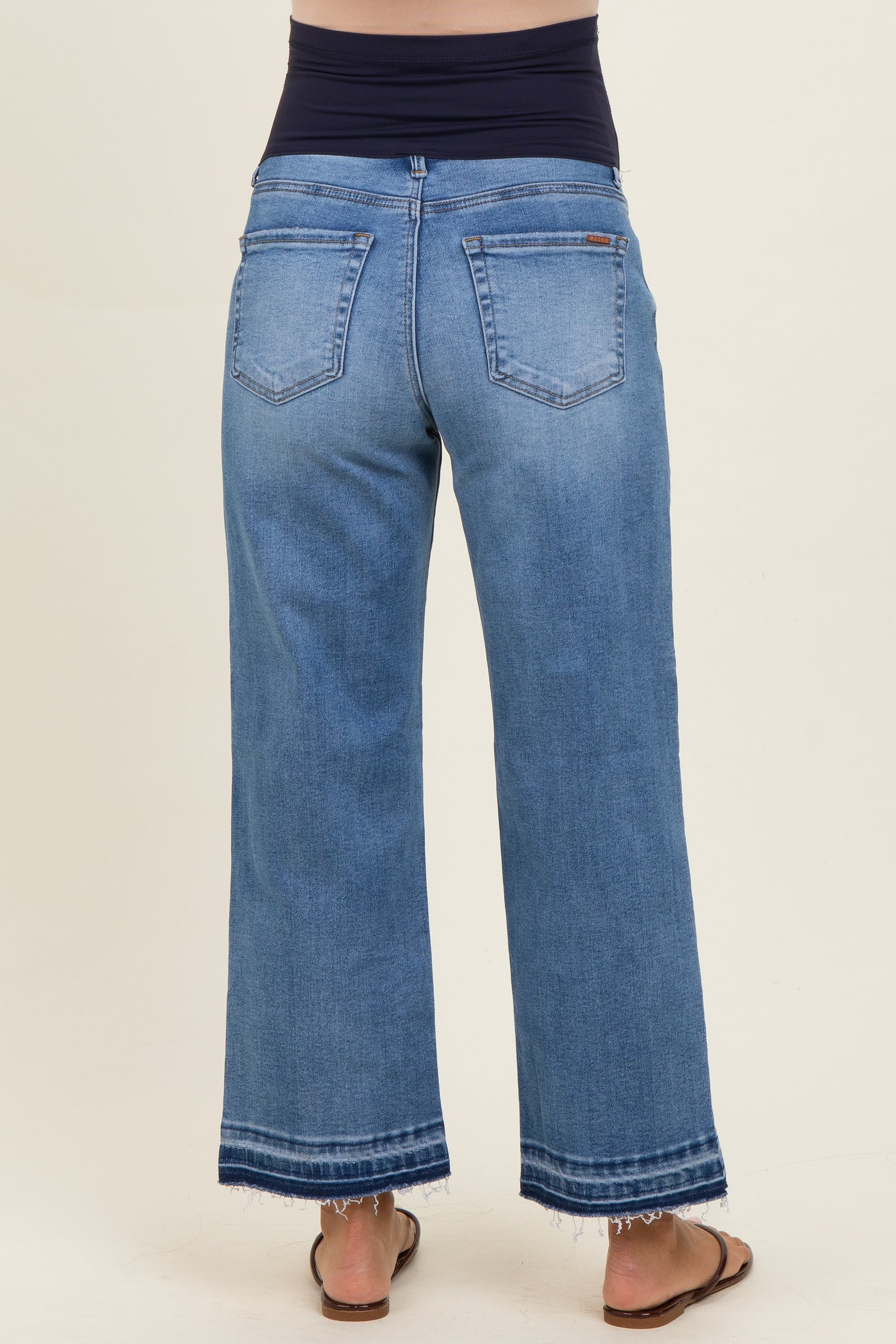 maternity wear wide-leg blue jeans with a dark waistband and frayed hem, being worn by a model from the back