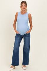 woman wearing a light blue ribbed maternity tank top and blue wide-leg jeans, showing her baby bump