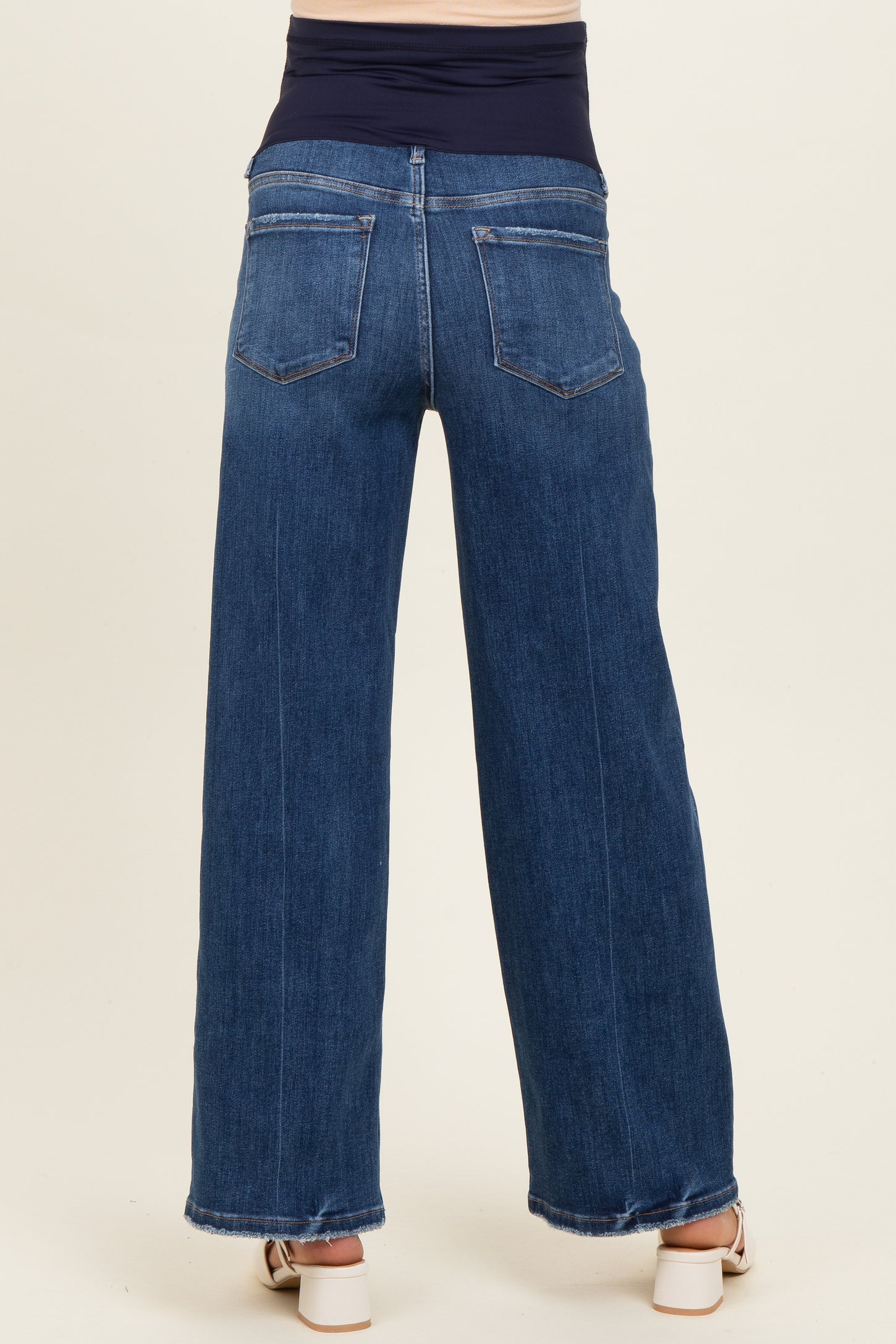 maternity wear dark wash wide leg jeans with a stretchy navy blue waistband and back pockets, model is seen from behind