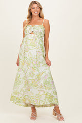 woman wearing a floral print maternity maxi dress with a ruffled neckline and a subtle baby bump visible