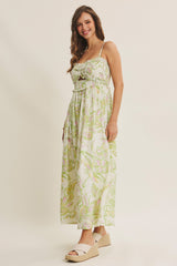 woman wearing a floral maxi dress with green and pink patterns and white espadrille sandals