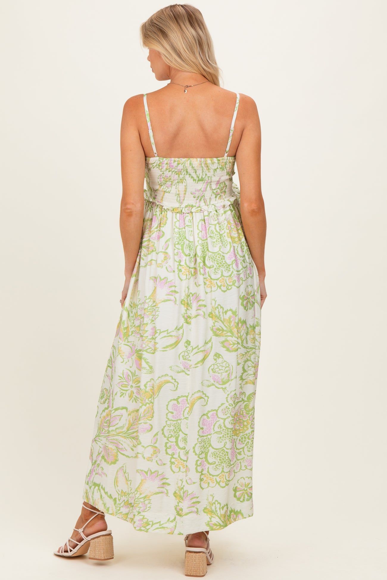 woman wearing a floral print maternity maxi dress with smocked back and adjustable straps