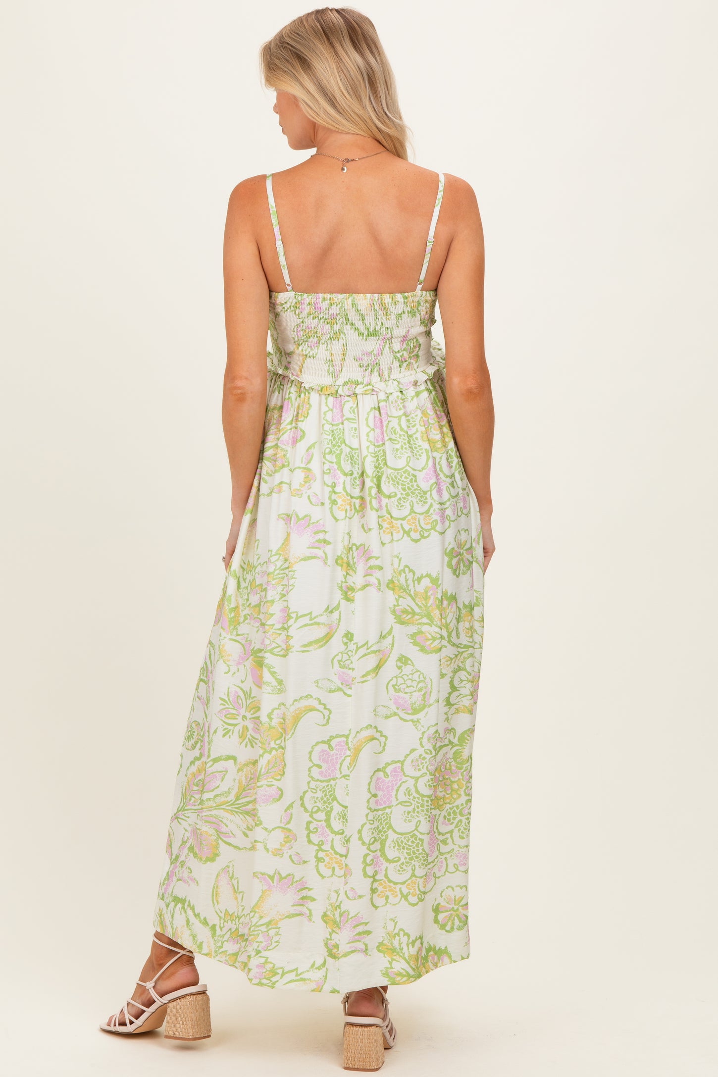 woman wearing a floral print maternity maxi dress with smocked back and adjustable straps