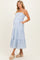 woman wearing a light blue striped maternity maxi dress with pockets and spaghetti straps, showcasing her baby bump