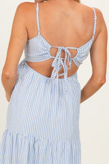 woman wearing a light blue and white striped maternity dress with a tie-back detail and a flowy skirt