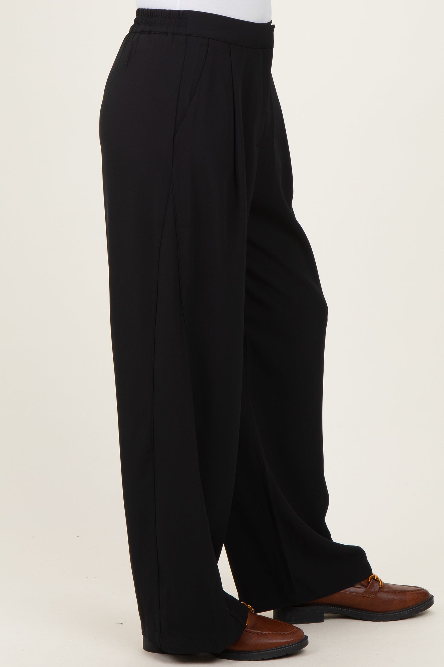 black wide-leg trousers with an elastic waistband and side pockets displayed on a white background