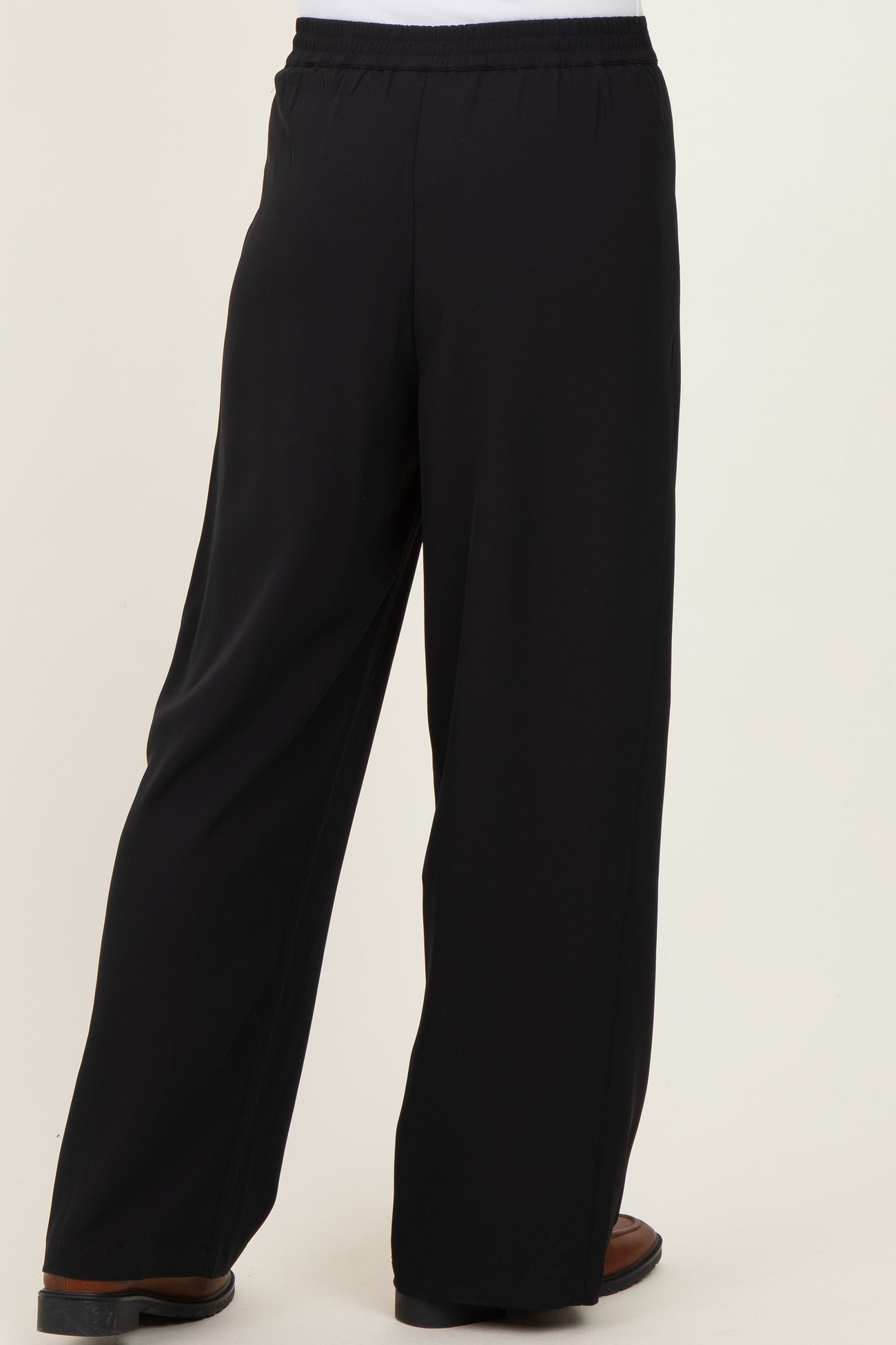 black wide-leg trousers with elastic waistband, shown from the back