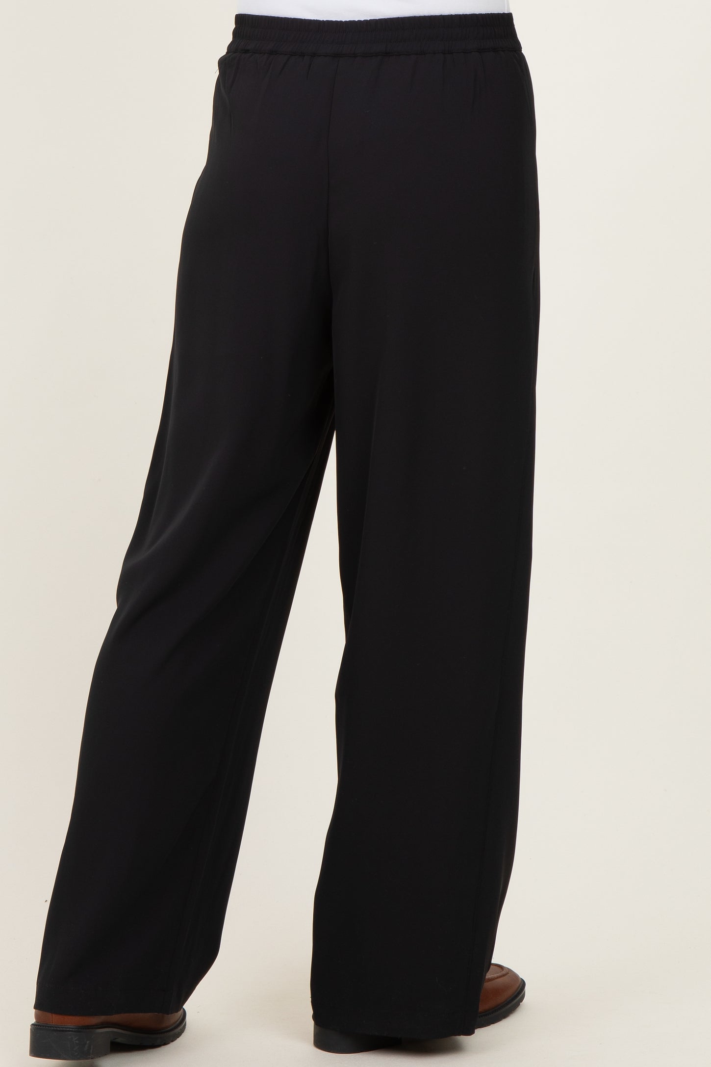 black wide-leg trousers with elastic waistband, shown from the back