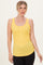 woman wearing a yellow ribbed tank top with a button detail, styled with black leggings