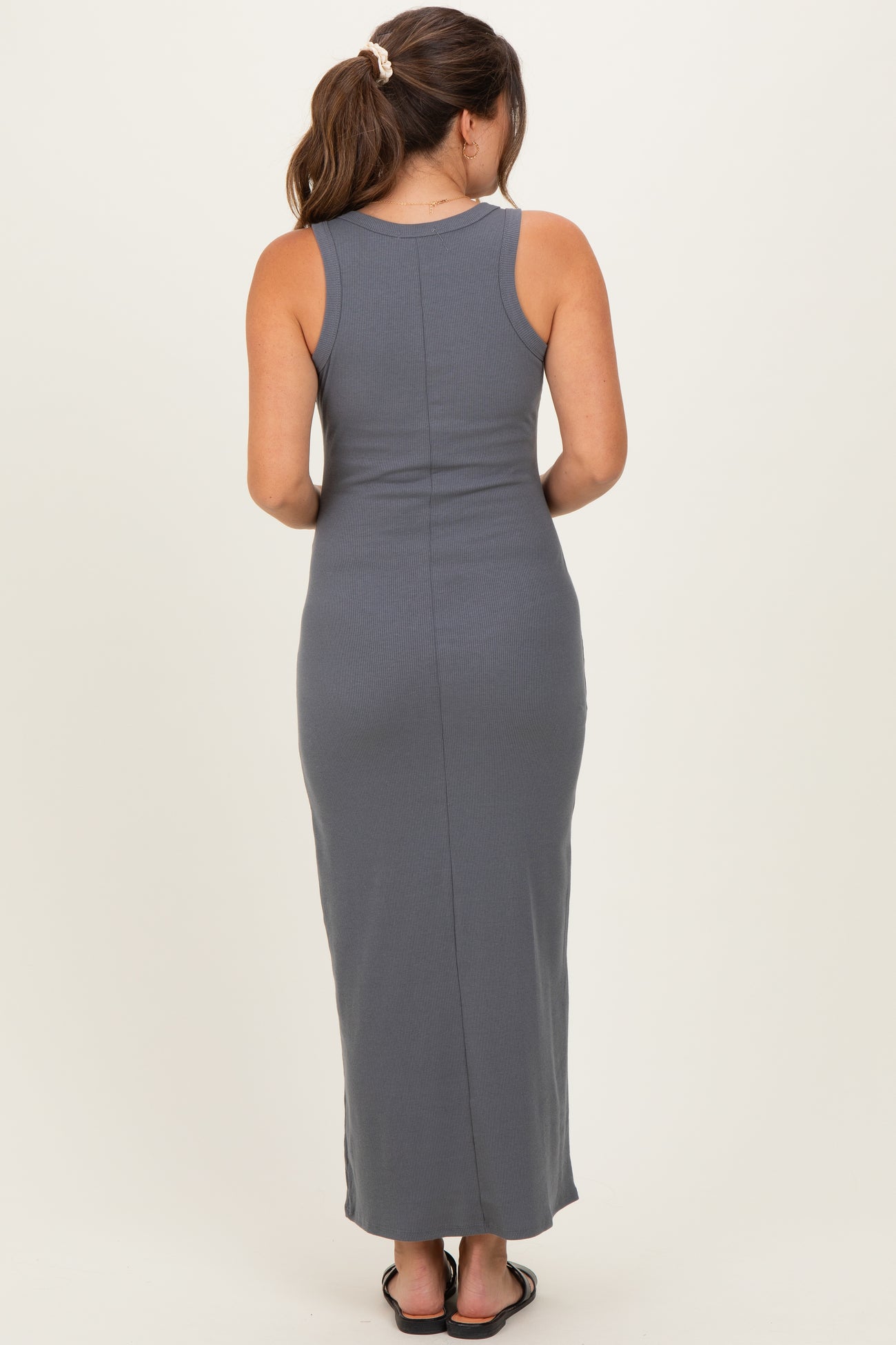 woman wearing a grey ribbed maternity maxi dress, showing the back view with a fitted silhouette