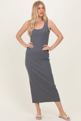 woman wearing a dark gray sleeveless maxi dress with a fitted silhouette and a scoop neckline