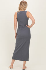 woman wearing a gray sleeveless maxi dress, viewed from the back, with a fitted silhouette and side slit
