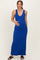 woman wearing a bright blue sleeveless maternity maxi dress and gently holding her baby bump