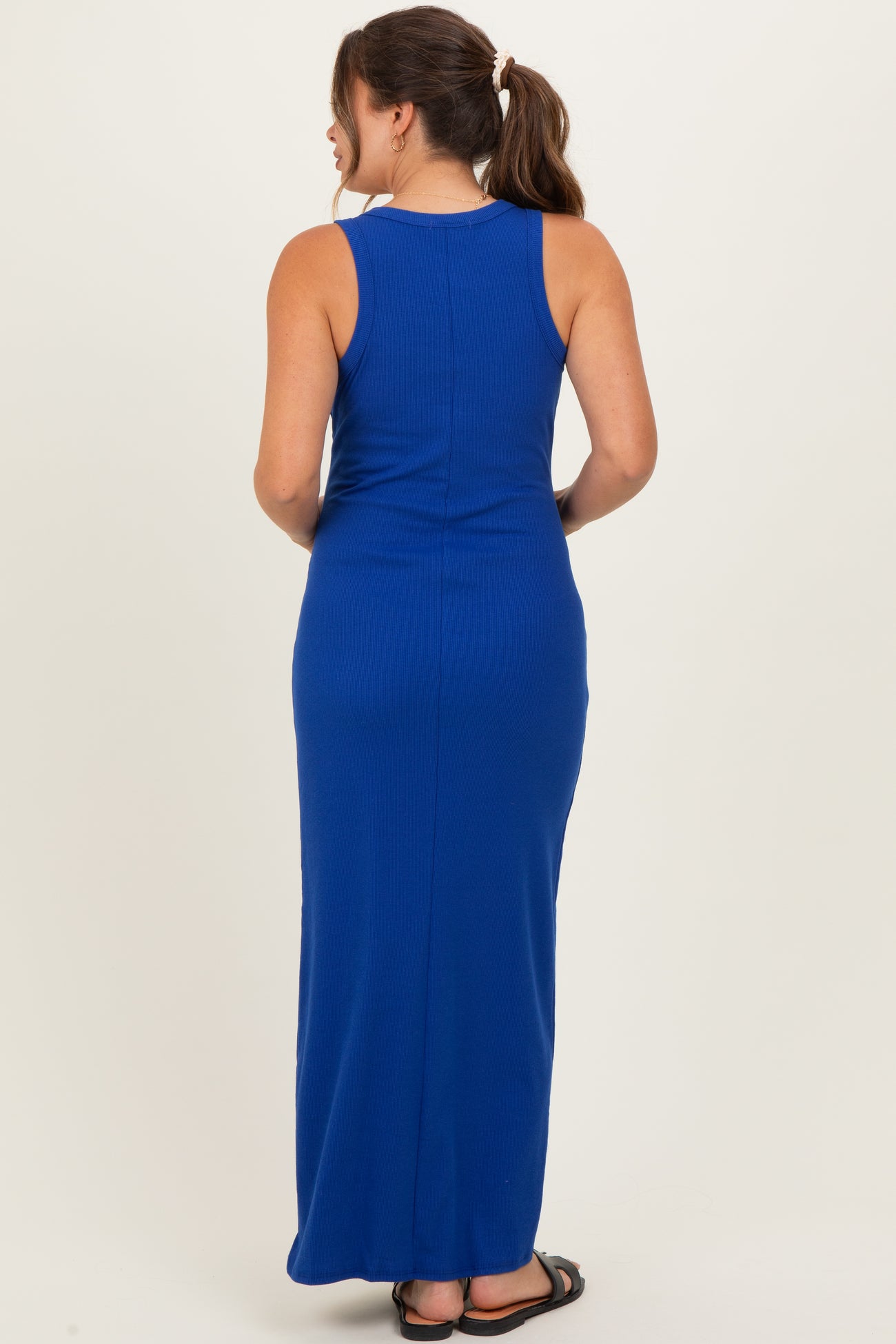 woman wearing a sleeveless royal blue maternity maxi dress, shown from the back