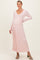 woman wearing a light pink long sleeve ribbed maternity dress with a tie waist and a visible baby bump