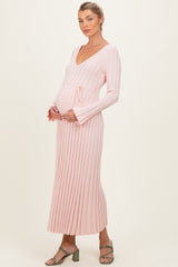woman wearing a light pink ribbed maternity dress with a tie waist and a visible baby bump