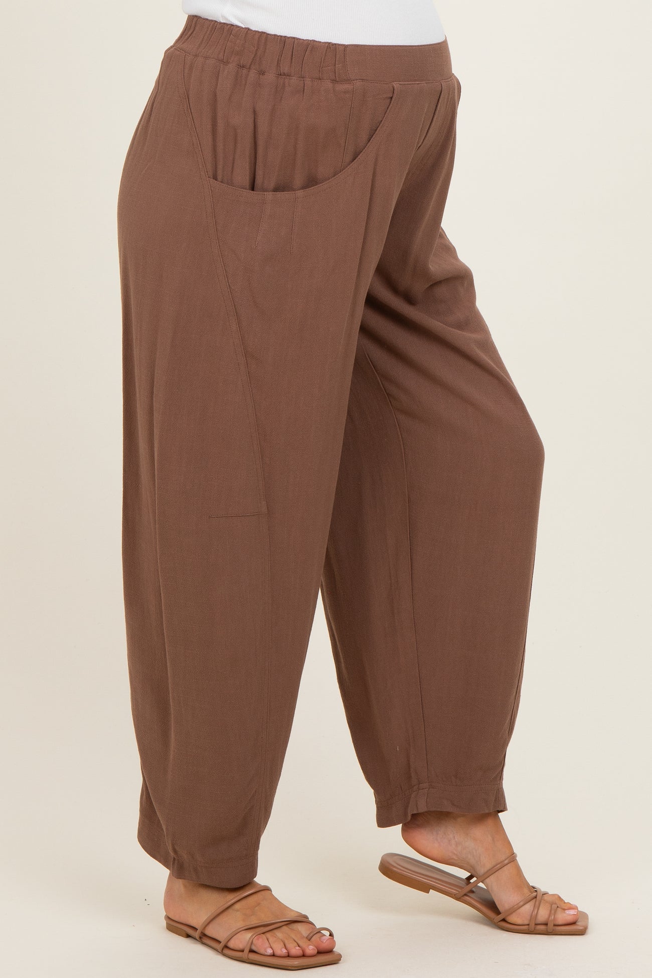 woman wearing brown maternity trousers with side pockets and a relaxed fit