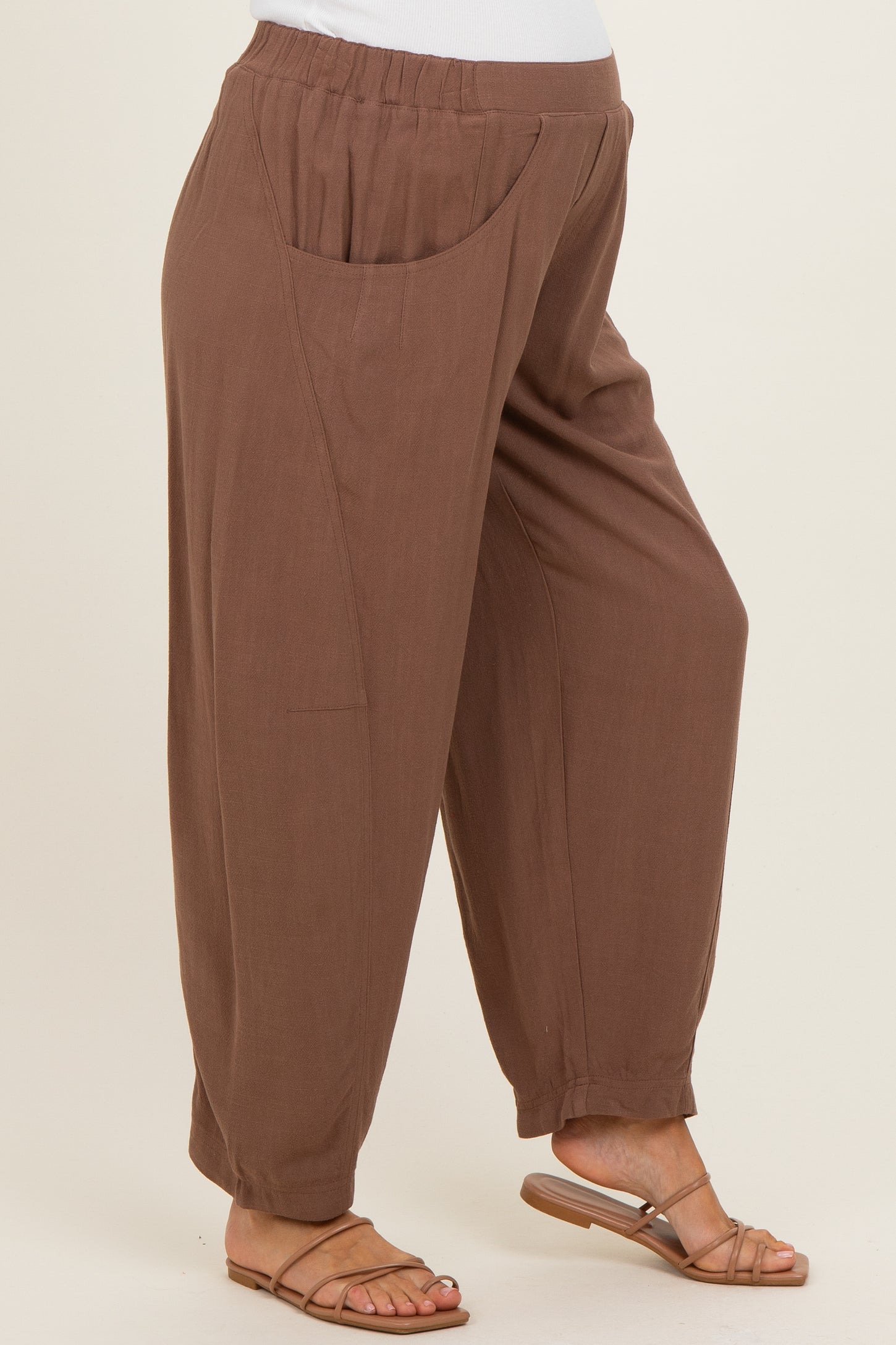 woman wearing brown maternity trousers with side pockets and a relaxed fit