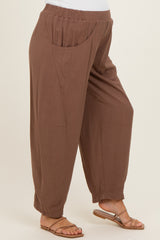 woman wearing brown maternity trousers with side pockets and a relaxed fit