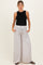 woman wearing a black ribbed maternity tank top and light grey wide-leg maternity pants with pockets and drawstring waist