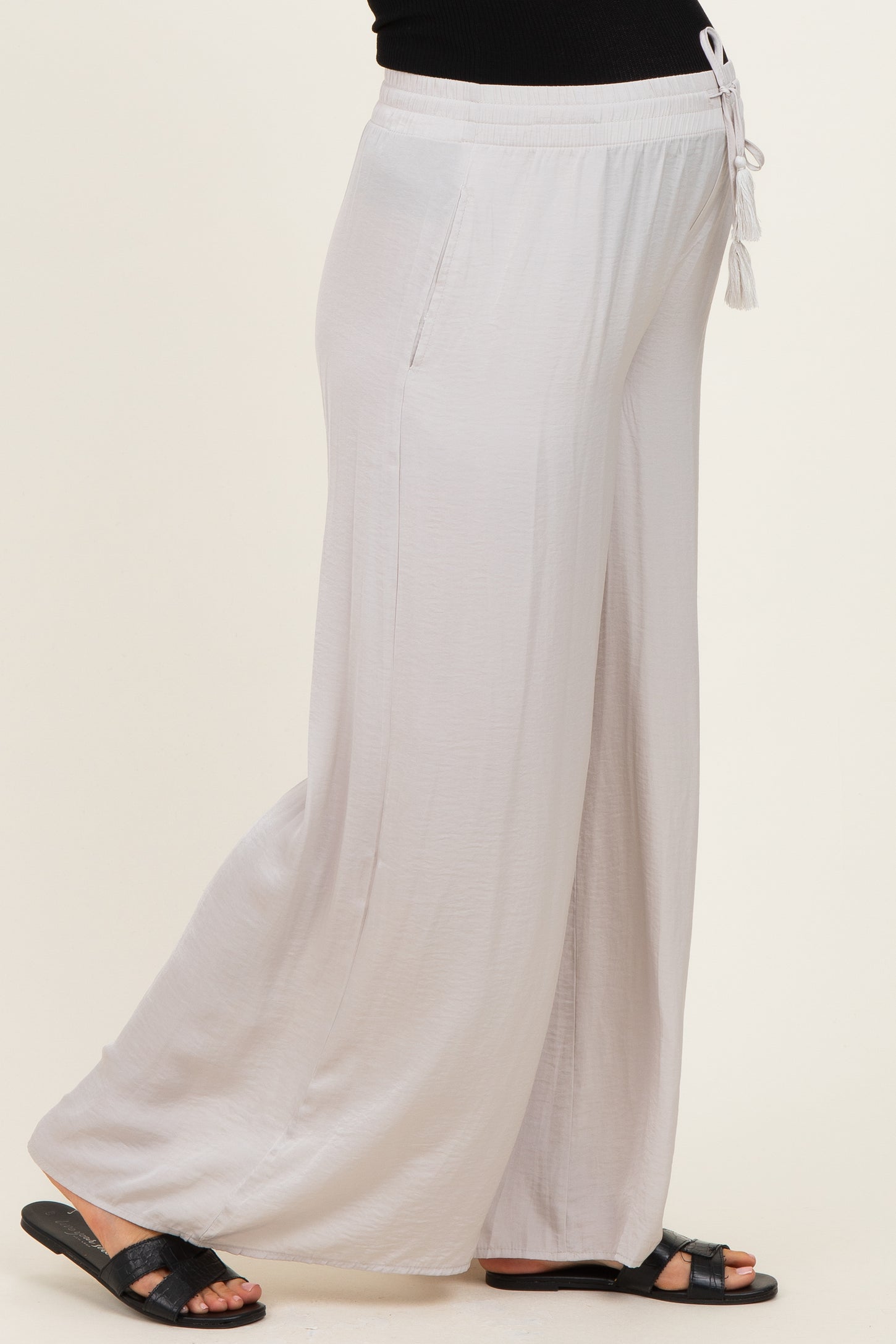 maternity wear light gray wide-leg pants with an elastic waistband and drawstring, model showing a baby bump