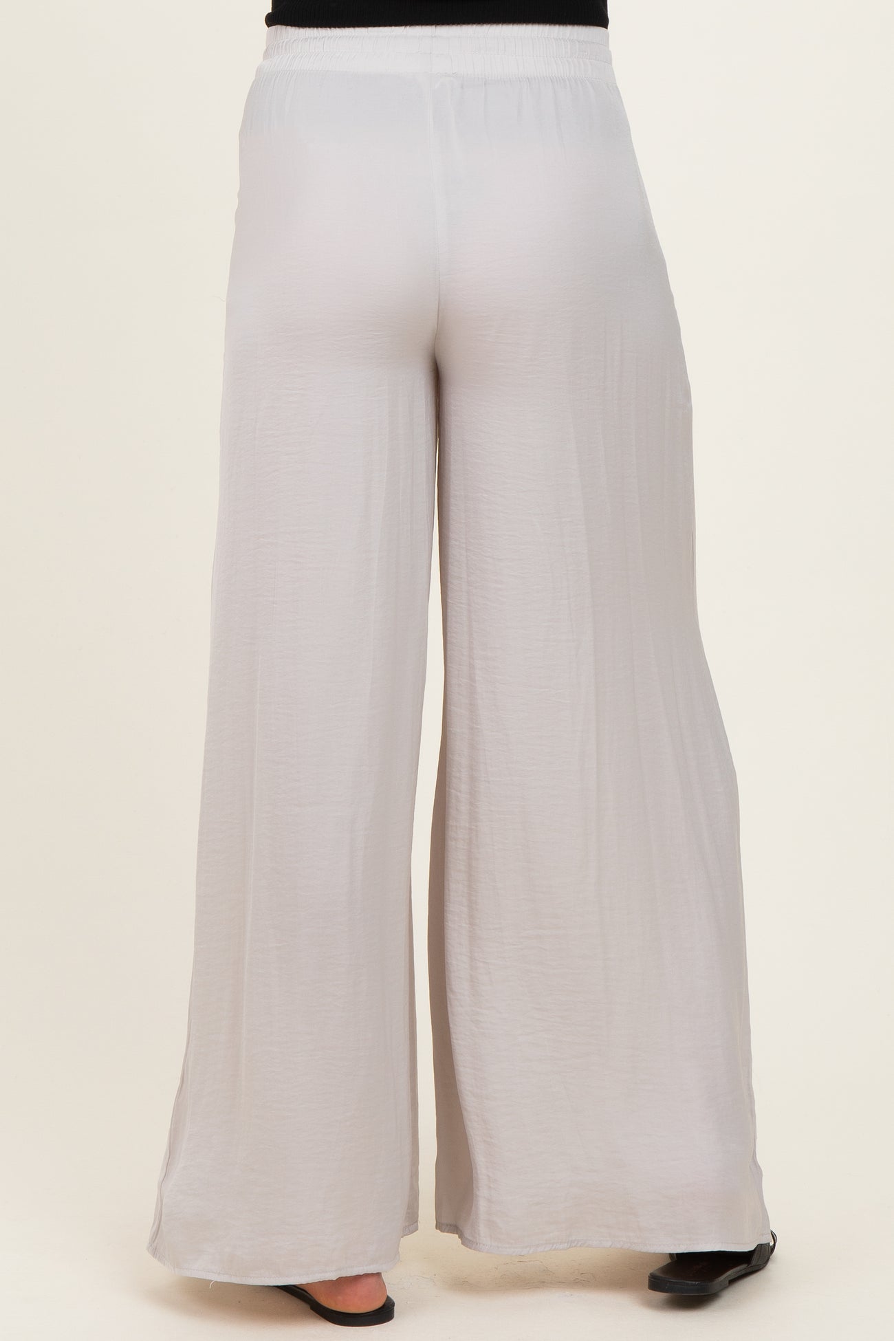 woman wearing light gray maternity wide-leg pants, showcasing a relaxed fit and elastic waistband