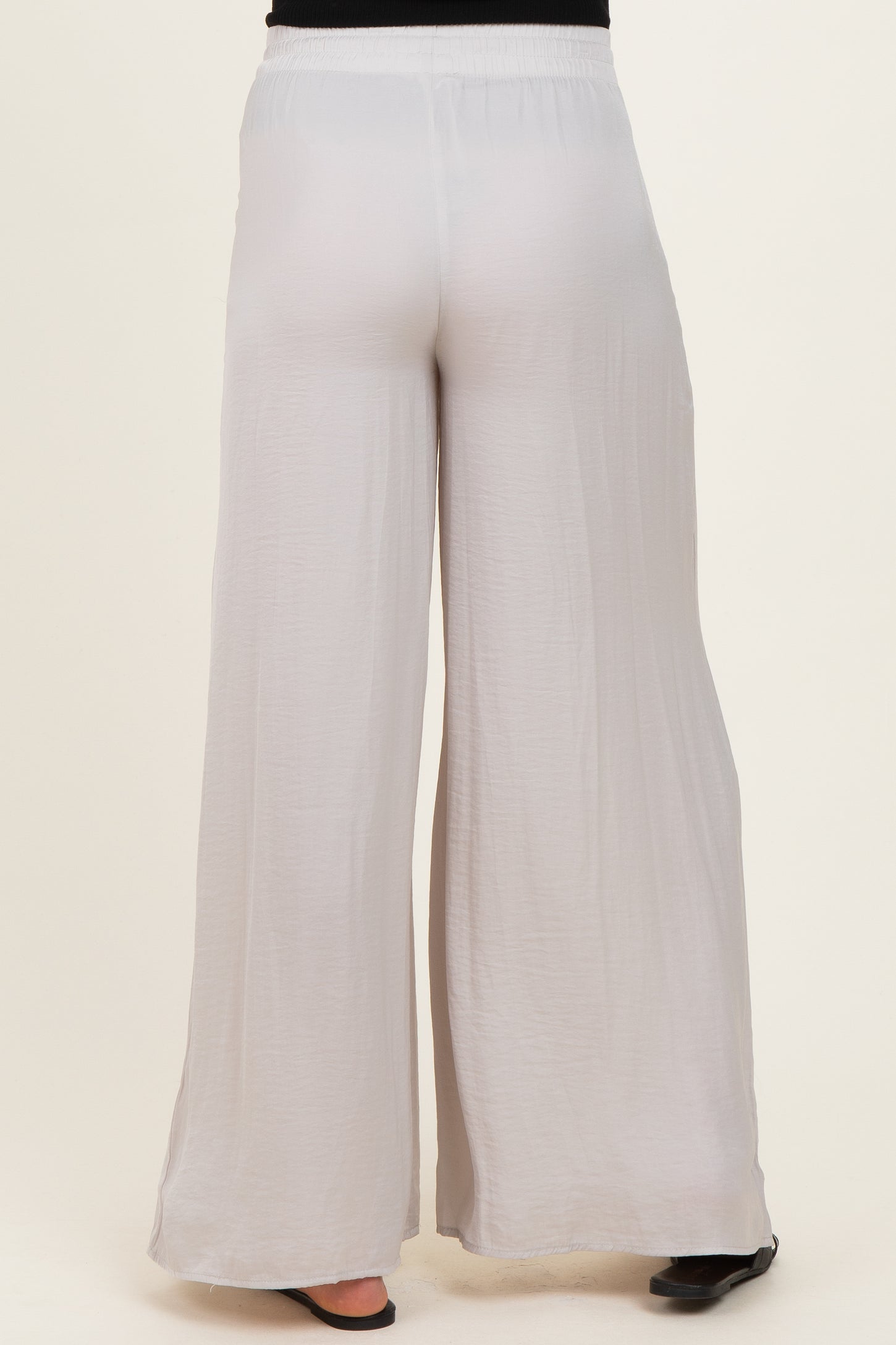 woman wearing light gray maternity wide-leg pants, showcasing a relaxed fit and elastic waistband