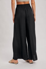 woman wearing black wide-leg pants with an elastic waistband, viewed from the back