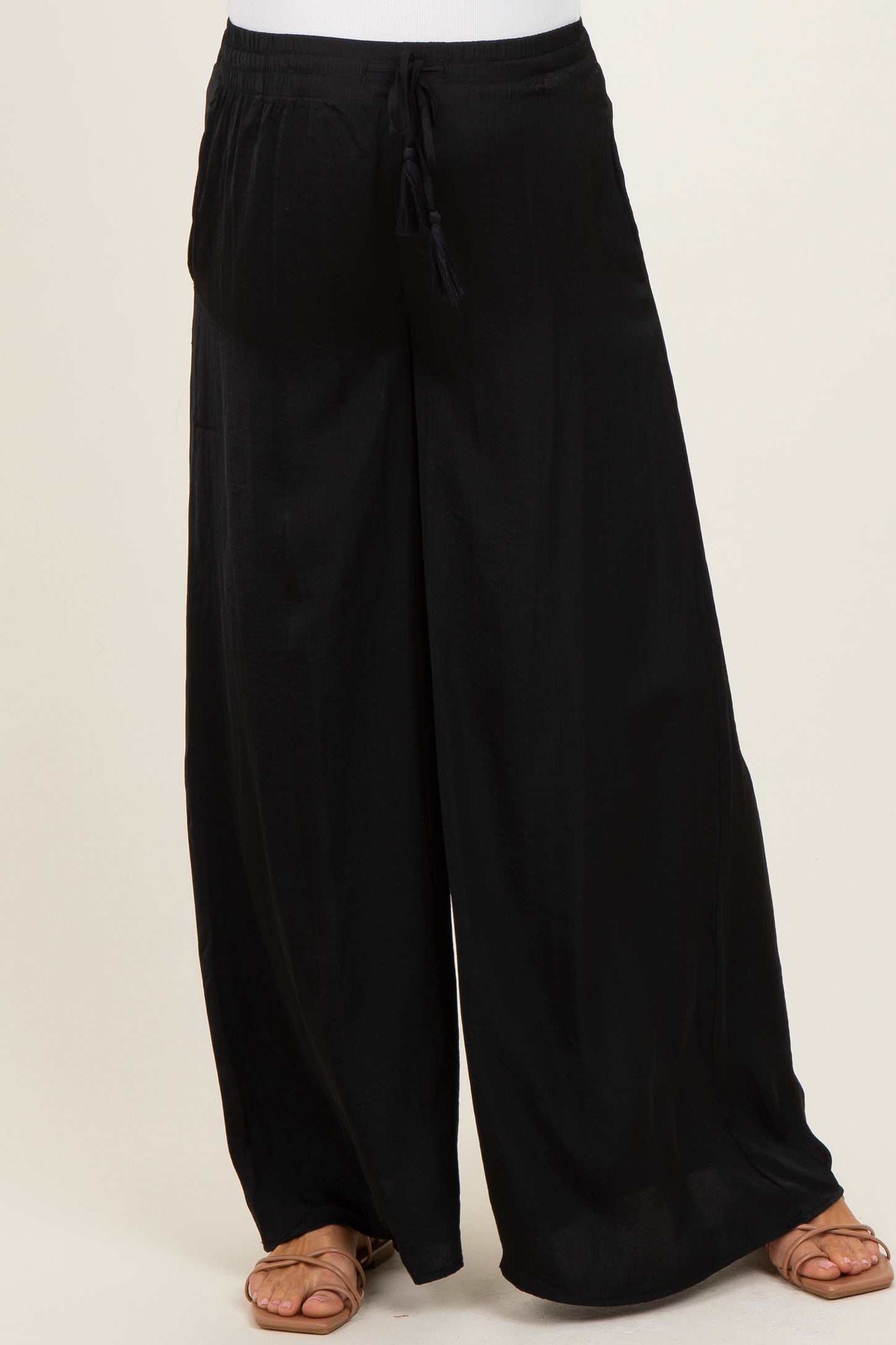woman wearing black flowy maternity pants with a comfortable elastic waistband and side pockets