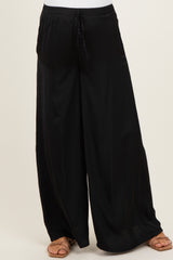 woman wearing black flowy maternity pants with a comfortable elastic waistband and side pockets