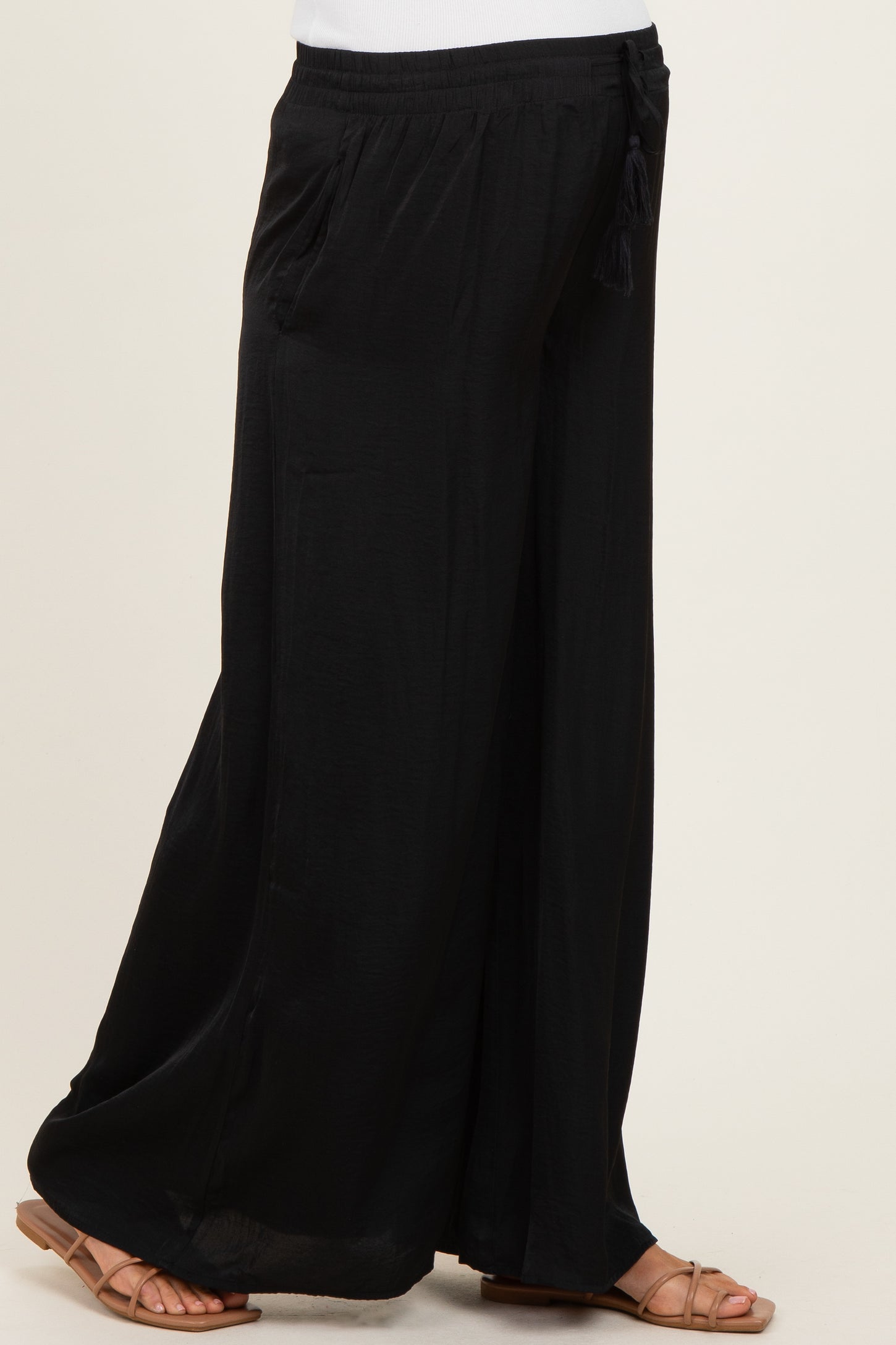 woman wearing black wide-leg maternity pants with a drawstring waist and side pockets