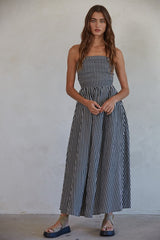 woman wearing a black and white striped maxi dress with a smocked bodice and aFlowy skirt