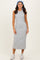 woman wearing a gray sleeveless midi dress and a blue patterned headband with white sneakers