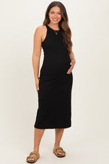 woman wearing a black maternity midi dress and holding her baby bump