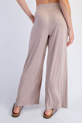 woman wearing beige wide-leg lounge pants, showing the back view with an elastic waistband